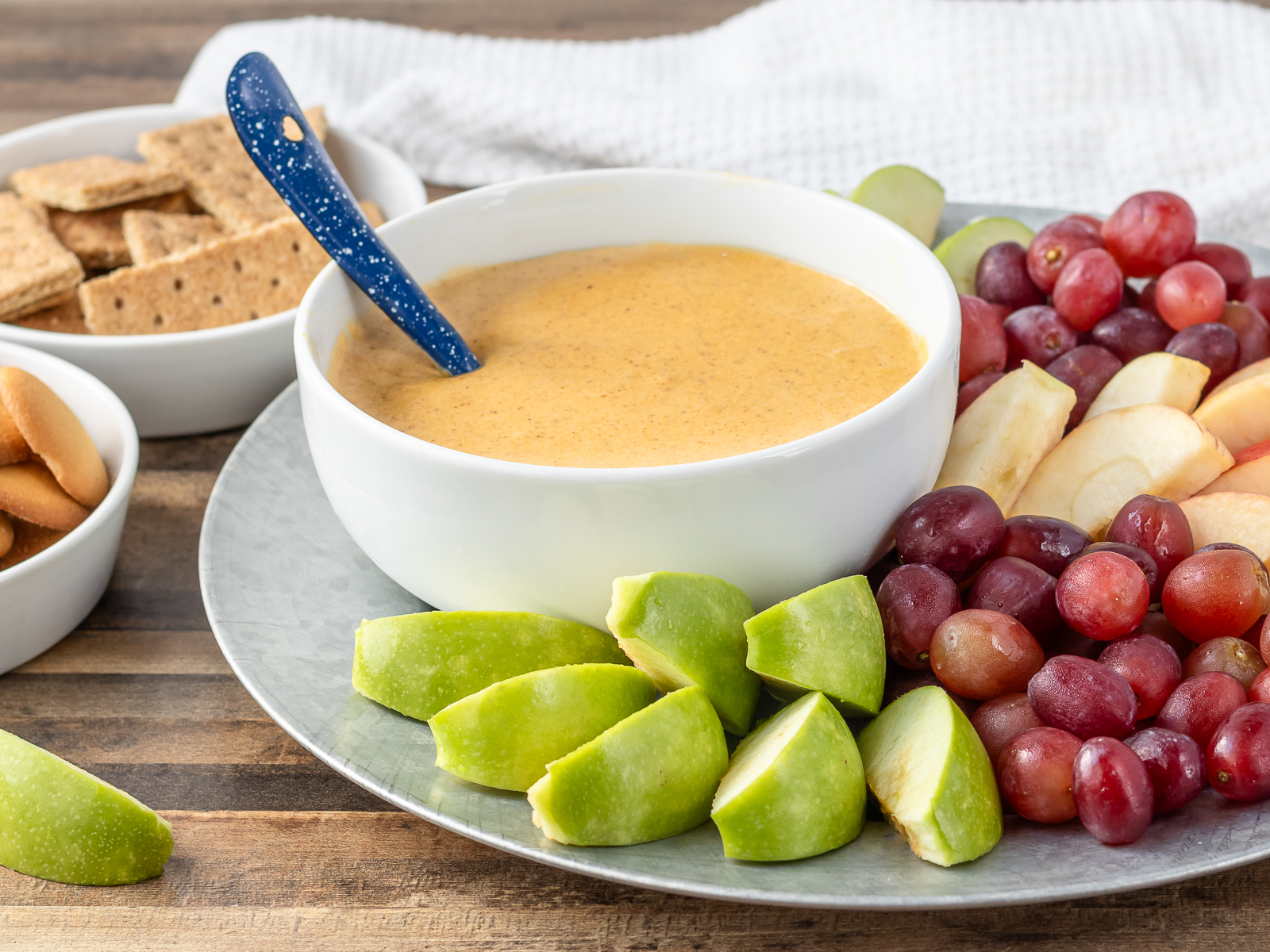 Big bowl of Pumpkin and Maple Fruit Dip with fruits, cookies, and crackers for dipping.