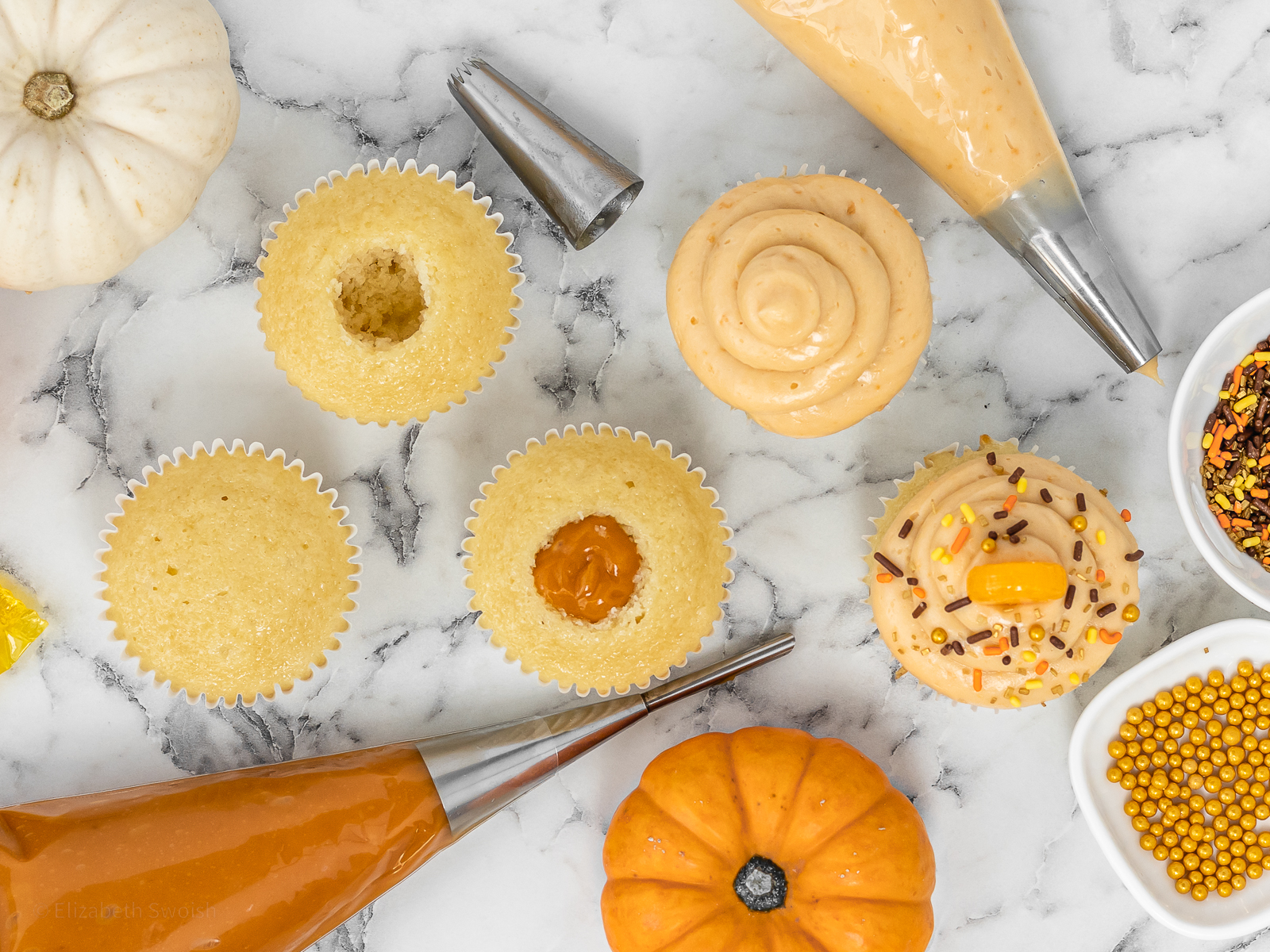 Row of cupcakes. The first is a whole vanilla cupcake, second has the center cored out, third the core is filled with butterscotch pudding, the fourth is topped with butterscotch buttercream, the fifth is decorated with festive fall sprinkles and a butterscotch candy.