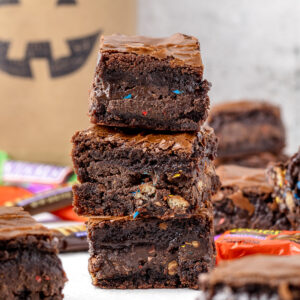 Stack of three Halloween Candy Brownies stuffed with a leftover chocolate layer.