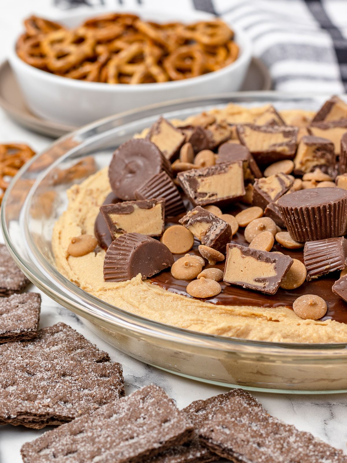 Dish filled with Chocolate Peanut Butter Pie Dip and topped with lots of peanut butter chips and peanut butter cups.