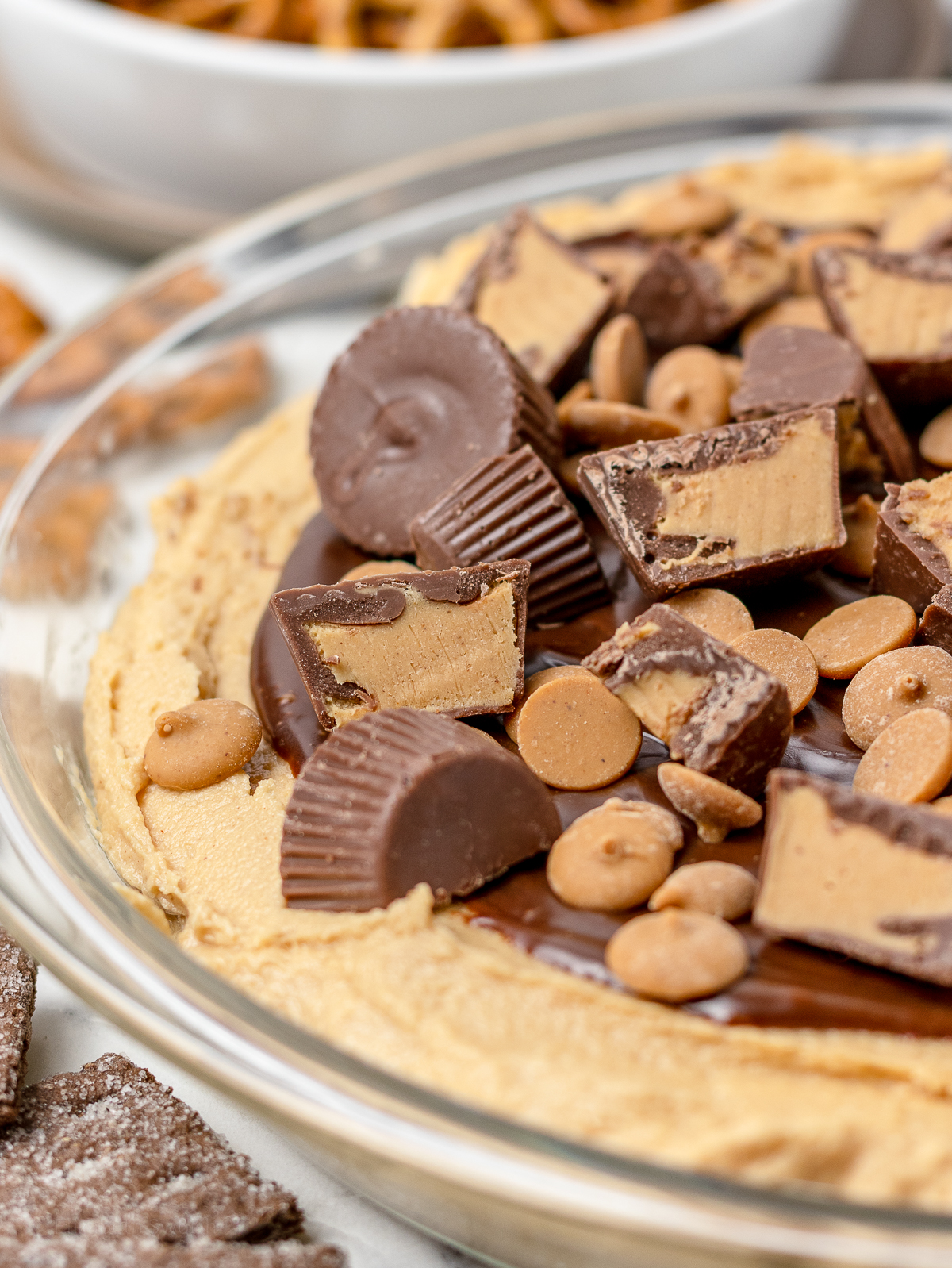 Close up of the creamy and fluffy dip topped with peanut butter cups and peanut butter chips.