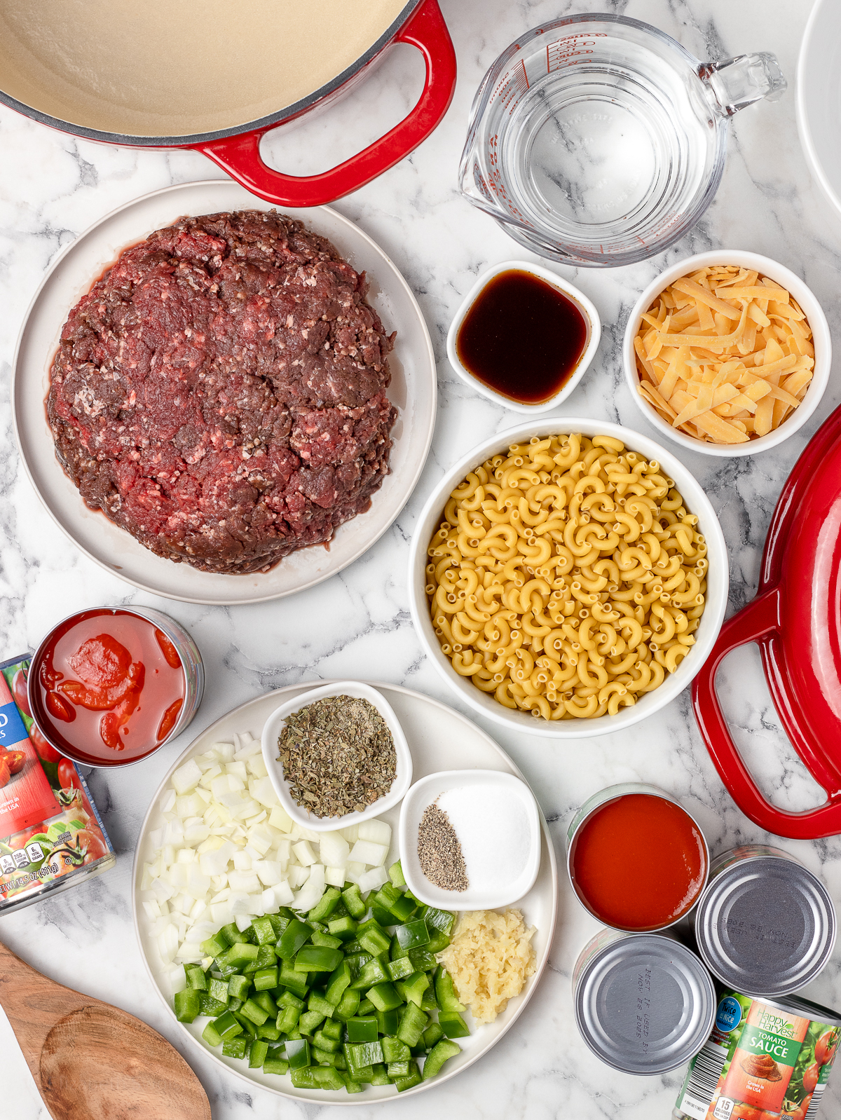 Ingredients for the recipe. Ground venison, yellow onion, green bell pepper, garlic, tomato sauce, stewed tomatoes, water, worcestershire sauce, italian seasoning, salt and black pepper, elbow macaroni, and medium cheddar cheese.