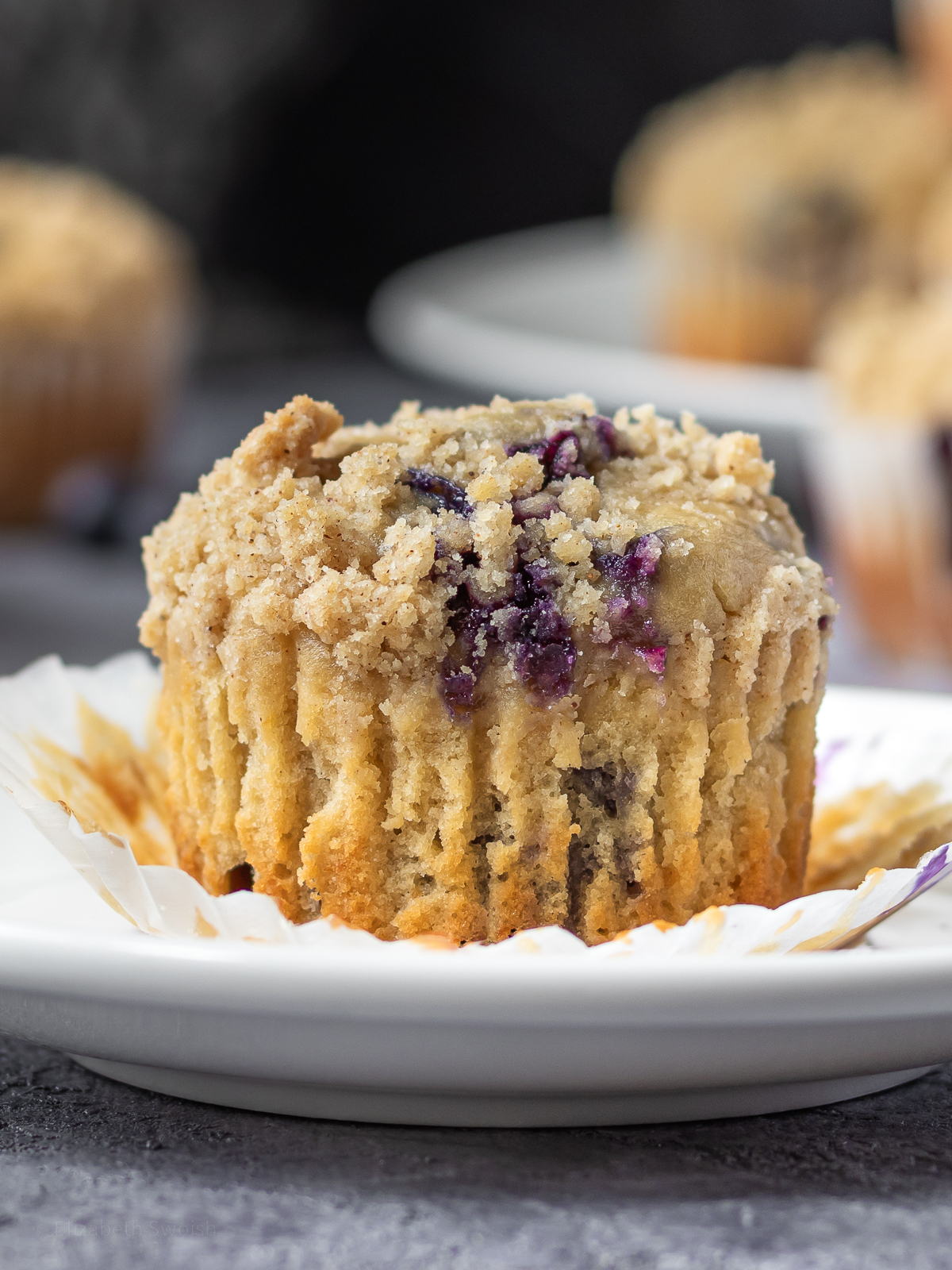 An unwrapped Blueberry Earl Grey Muffin topped with streusel.