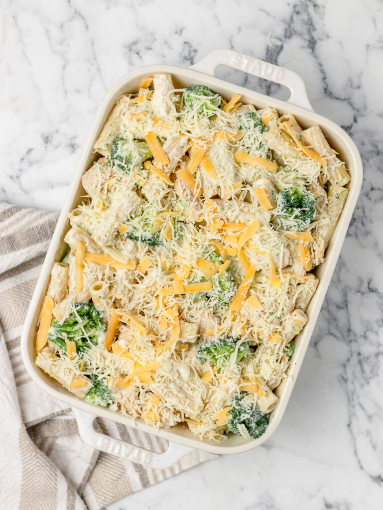 Step 6. The sauced chicken, broccoli, and pasta topped with both cheeses in a baking dish. Ready to bake in the oven.