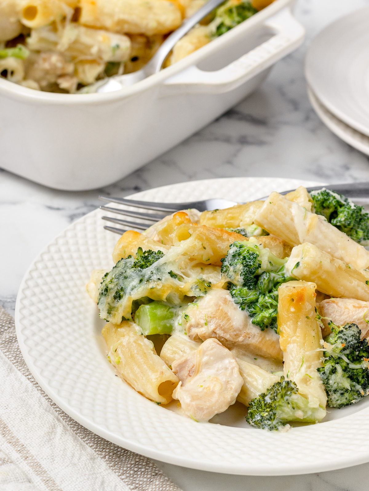 Baked Chicken and Broccoli Pasta on a plate with a fork ready to eat.