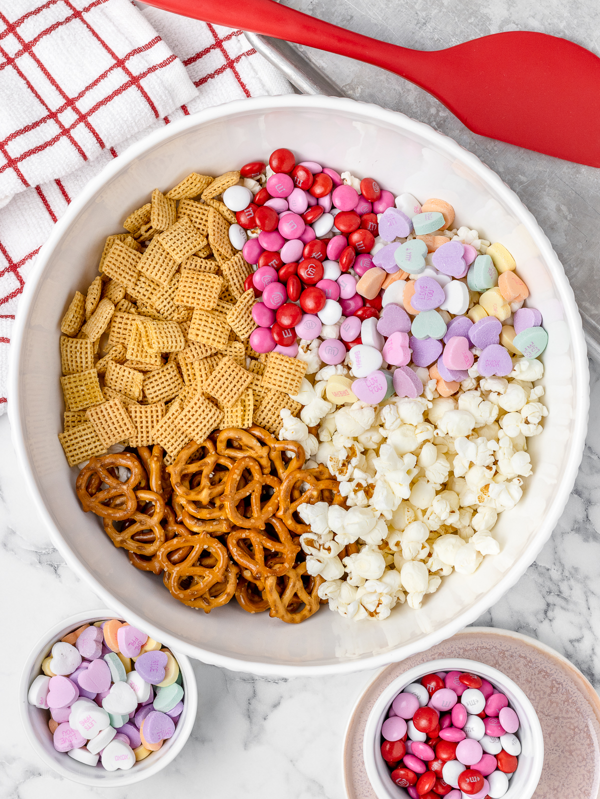 Step 2. Mixing together the plain popcorn, corn chex, mini pretzels, M&M's, and conversation hearts in a very large bowl.
