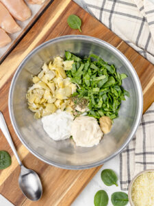 Step 1. Add chopped artichokes, chopped fresh spinach, mayonnaise, sour cream, dijon mustard, and seasonings to a bowl.