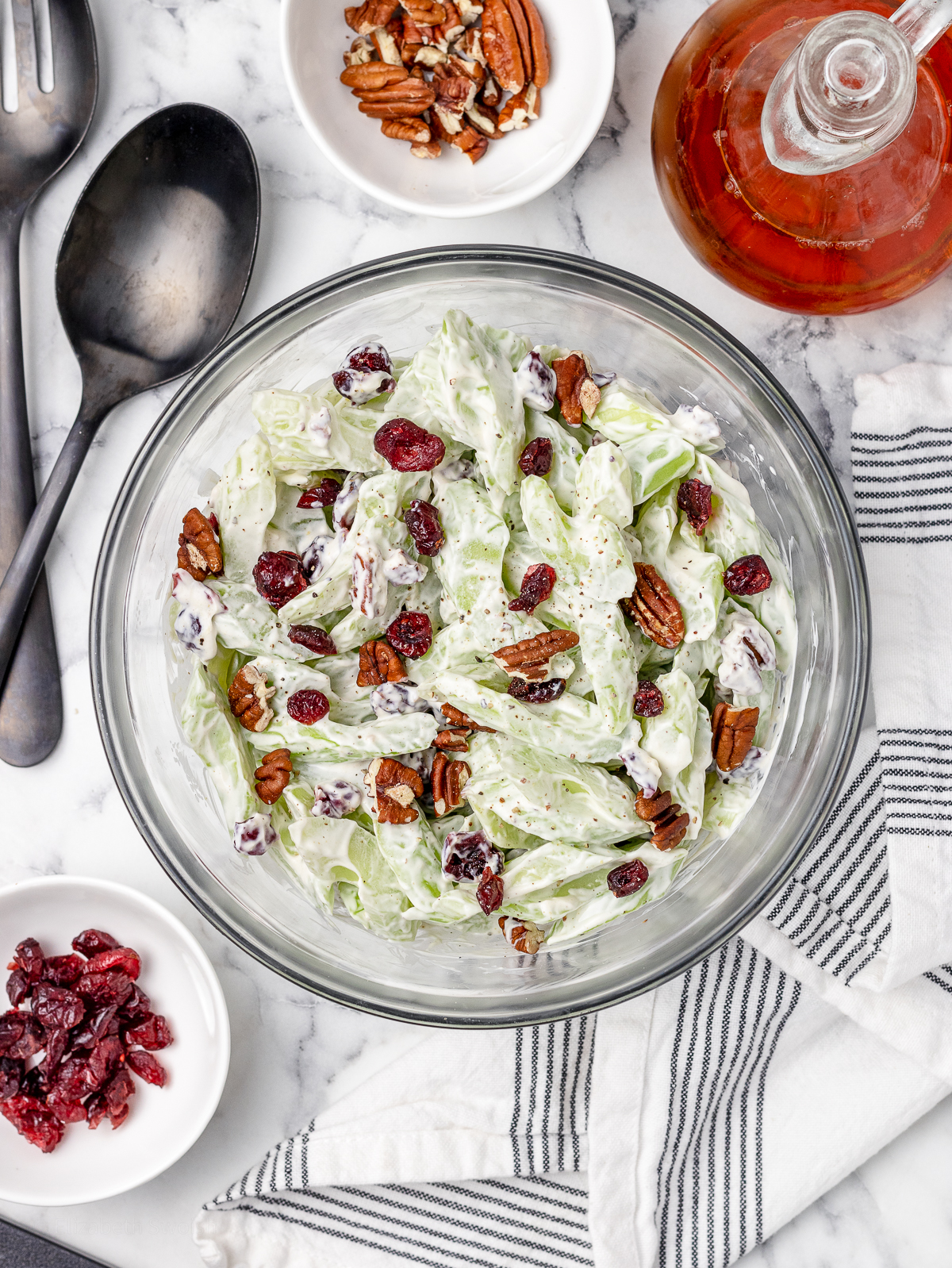 Celery Salad with red wine vinegar, more toasted pecans, and dried cranberries on the side. Serving spoons ready to scoop.