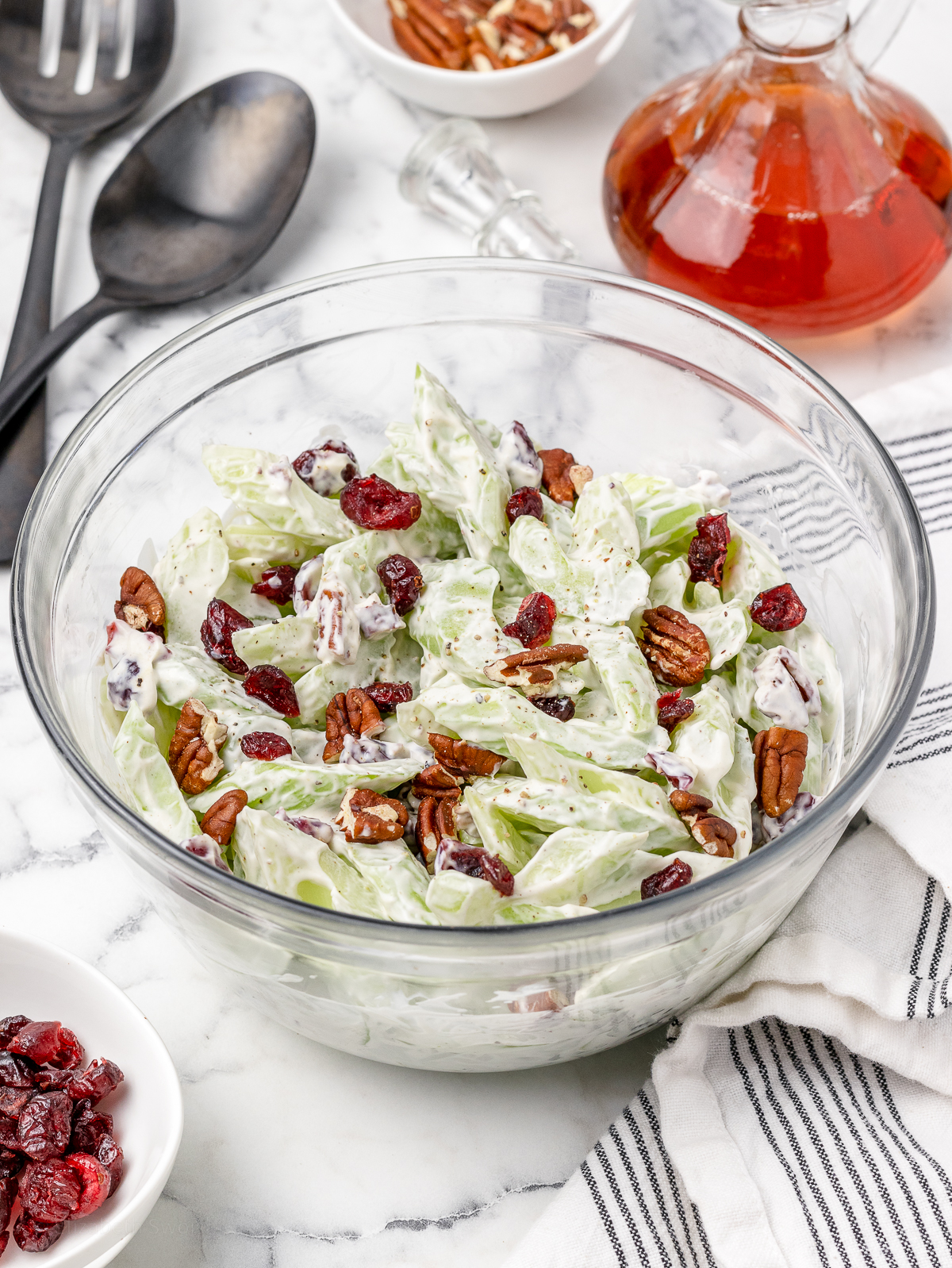 Creamy Salad with celery, toasted pecans, and dried cranberries. Large serving spoons on the side ready for scooping.