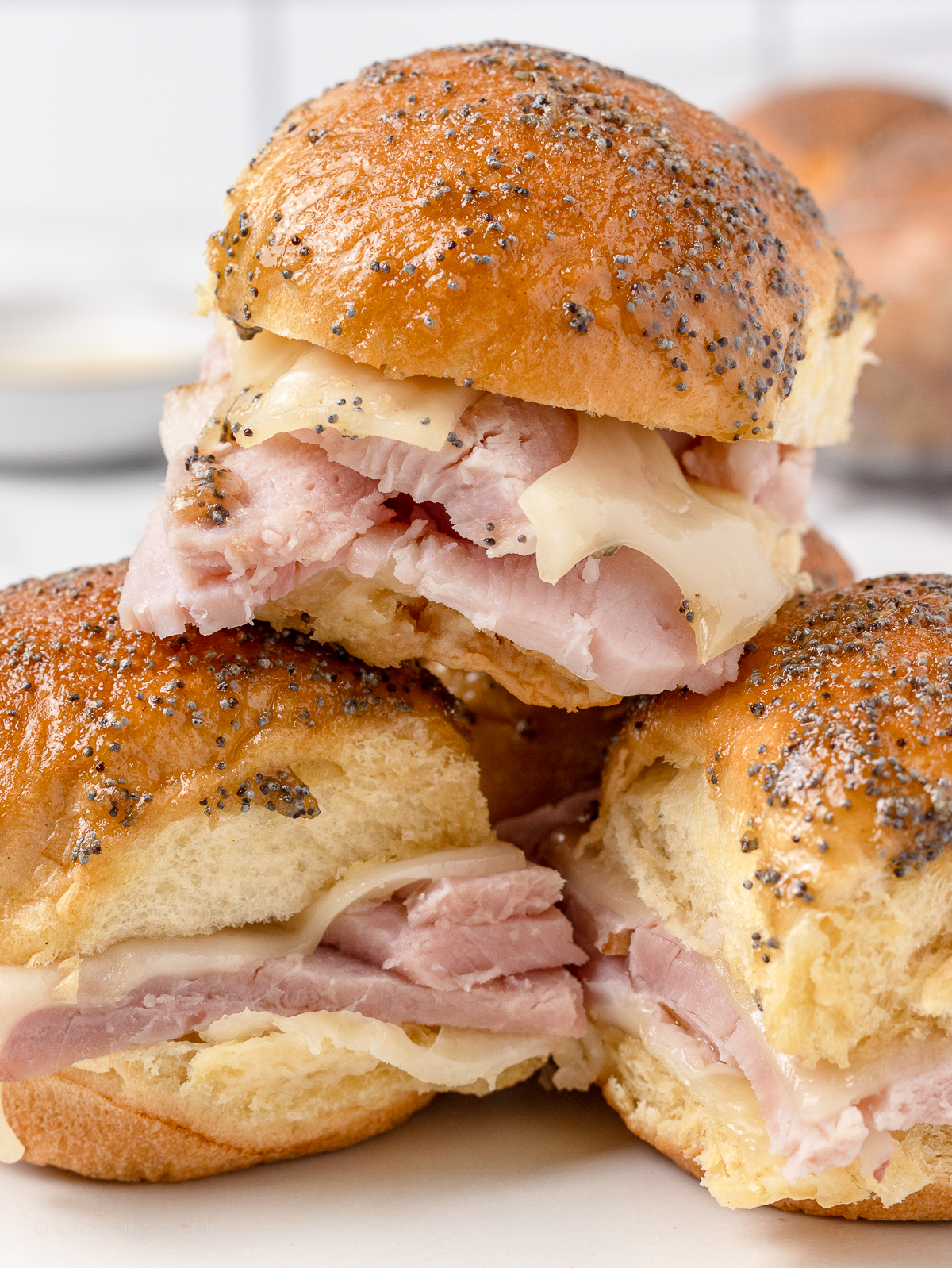 Stack of 3 Brown Sugar Ham and Cheese Sliders on a plate.