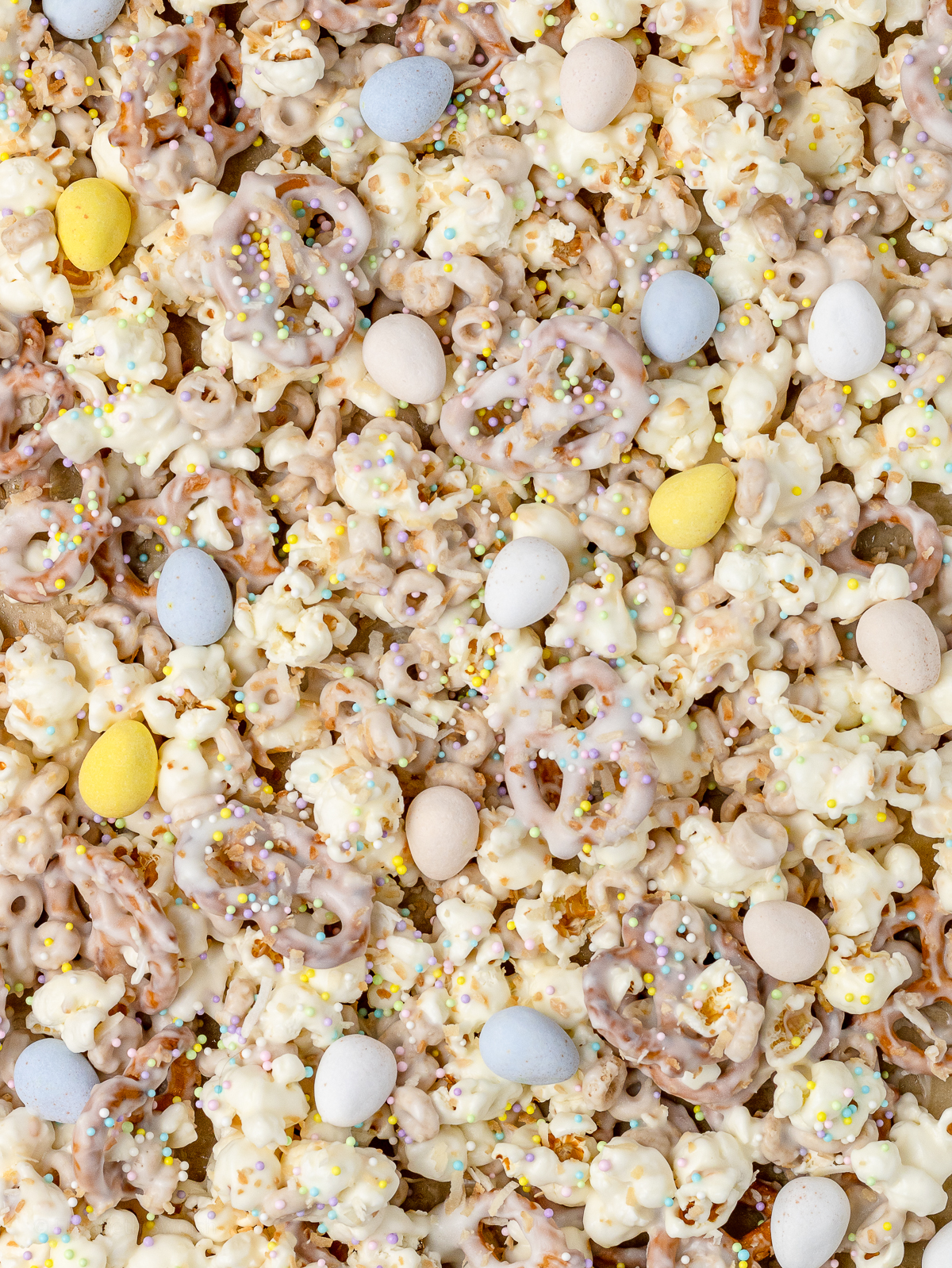 Close up of Bunny Popcorn Snack Mix to see the toasted coconut, milk chocolate candy eggs, and pastel Easter sprinkles.
