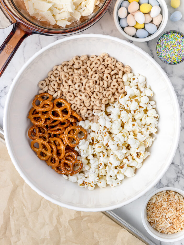 In a large bowl, mix together plain popcorn, toasted O's cereal, mini pretzels, and toasted unsweetened coconut.