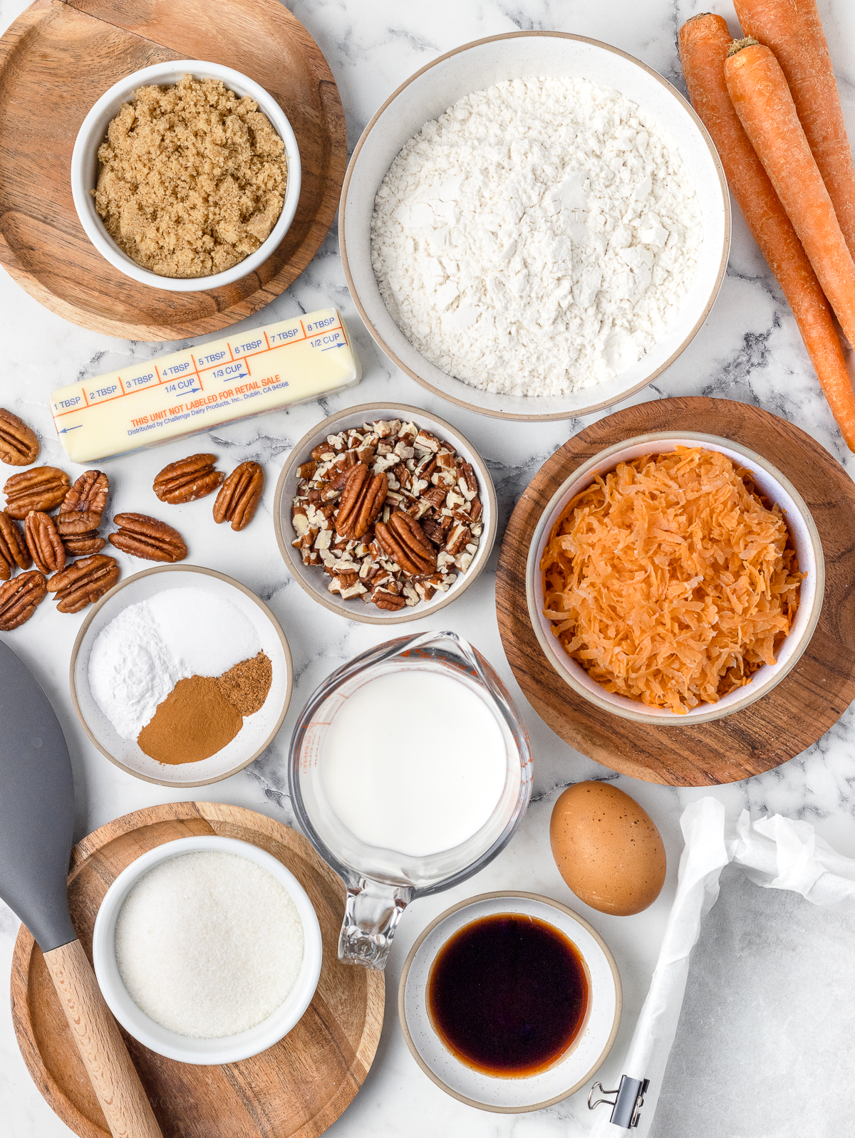 Ingredients. All purpose flour, baking powder, salt, cinnamon, nutmeg, unsalted butter, brown sugar, granulated sugar, egg, vanilla extract, buttermilk, shredded carrots, and toasted pecans.