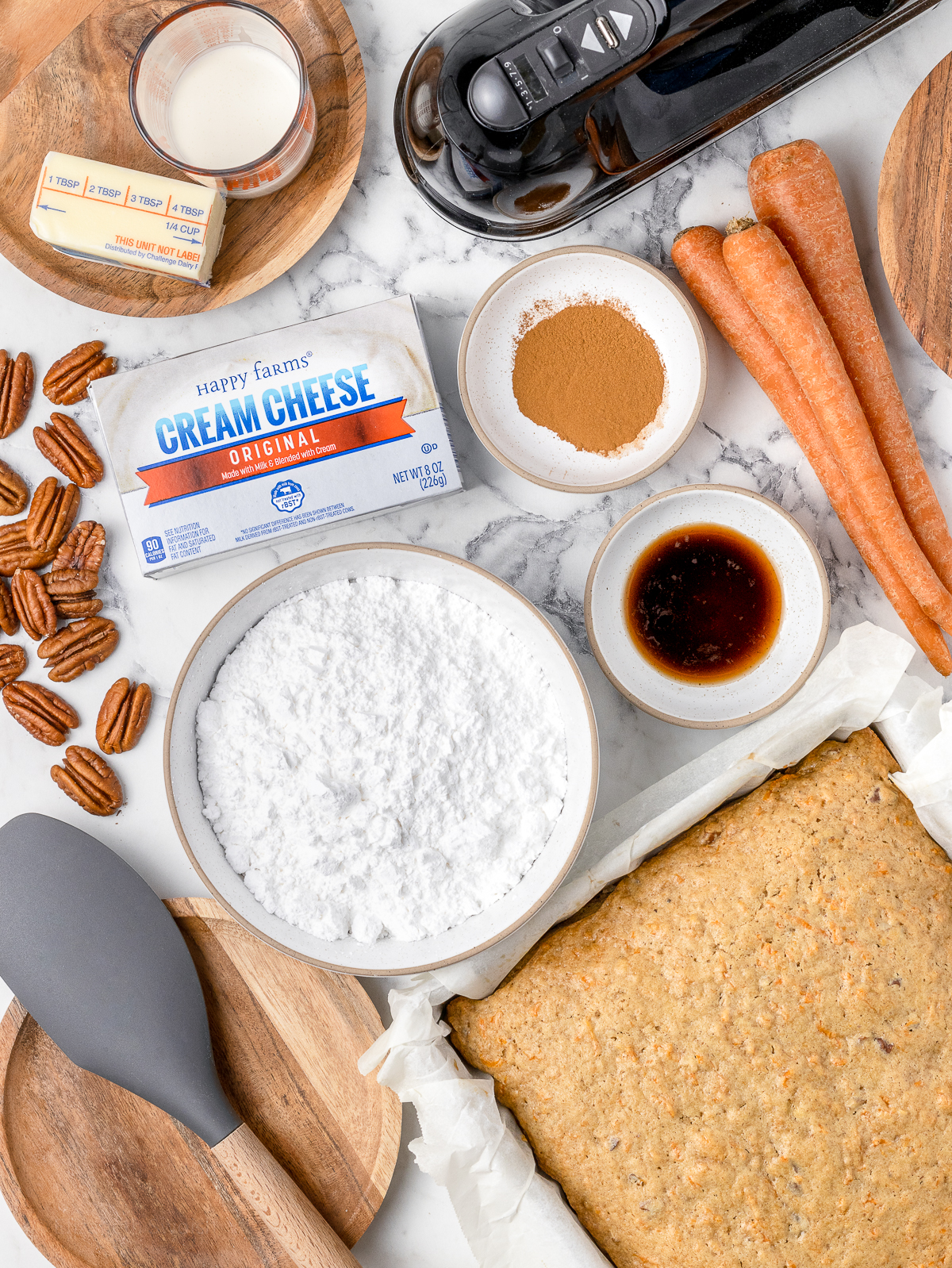 Ingredients. Cream cheese, unsalted butter, vanilla extract, powdered sugar, cinnamon, heavy whipping cream, and a fully baked carrot snack cake.