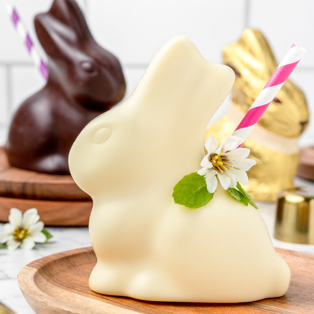 Chocolate Bunny Easter Mocktail 2 ways. A white chocolate bunny filled with an almond and coconut mocktail. A milk chocolate bunny filled with a rum and espresso mocktail. Both garnished with a fun striped straw.