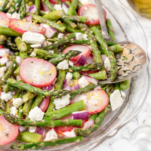 Roasted Asparagus Salad with radishes, feta cheese, and red onion. A big serving spoon on the side for scooping.