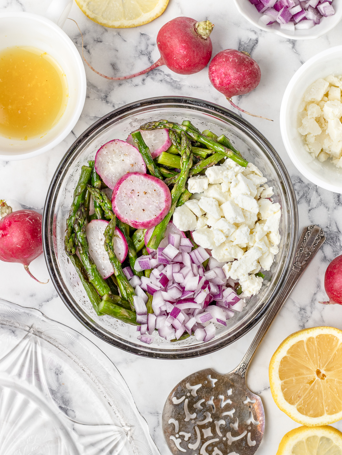 Directions 2. Roasted asparagus and radishes in a bowl with red onion, feta cheese, lemon juice and lemon zest. Ready to be tossed and served.