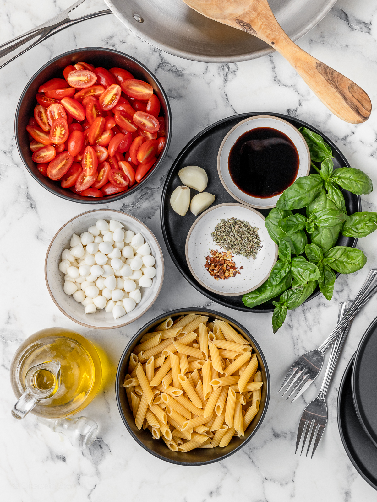 Ingredients. Penne pasta, cherry tomatoes, mozzarella pearls, fresh basil, fresh garlic, olive oil, Italian seasoning, red pepper flakes, and balsamic glaze.