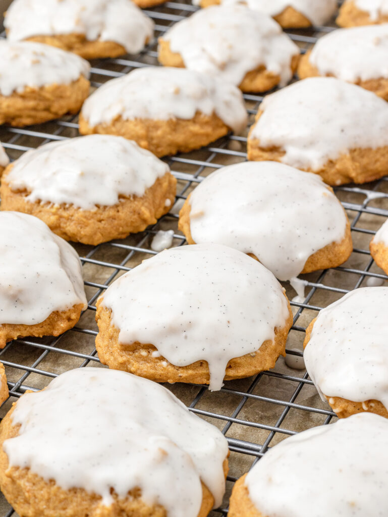 24 glazed cookies on a baking sheet drying.