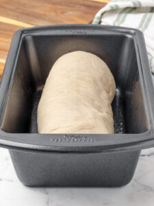 Bread dough shaped into a log shaped loaf. It is placed in a greased bread pan to rise and double in size.