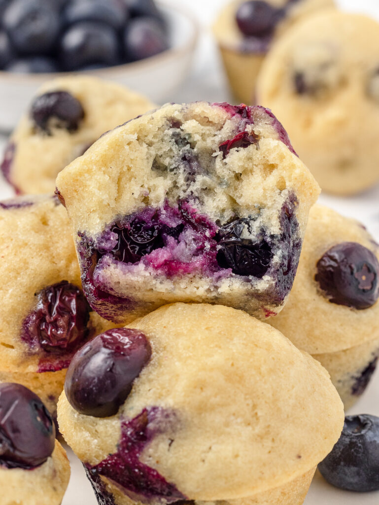 The center of a Mini Blueberry Muffin to see bursting blueberries and a tender crumb.