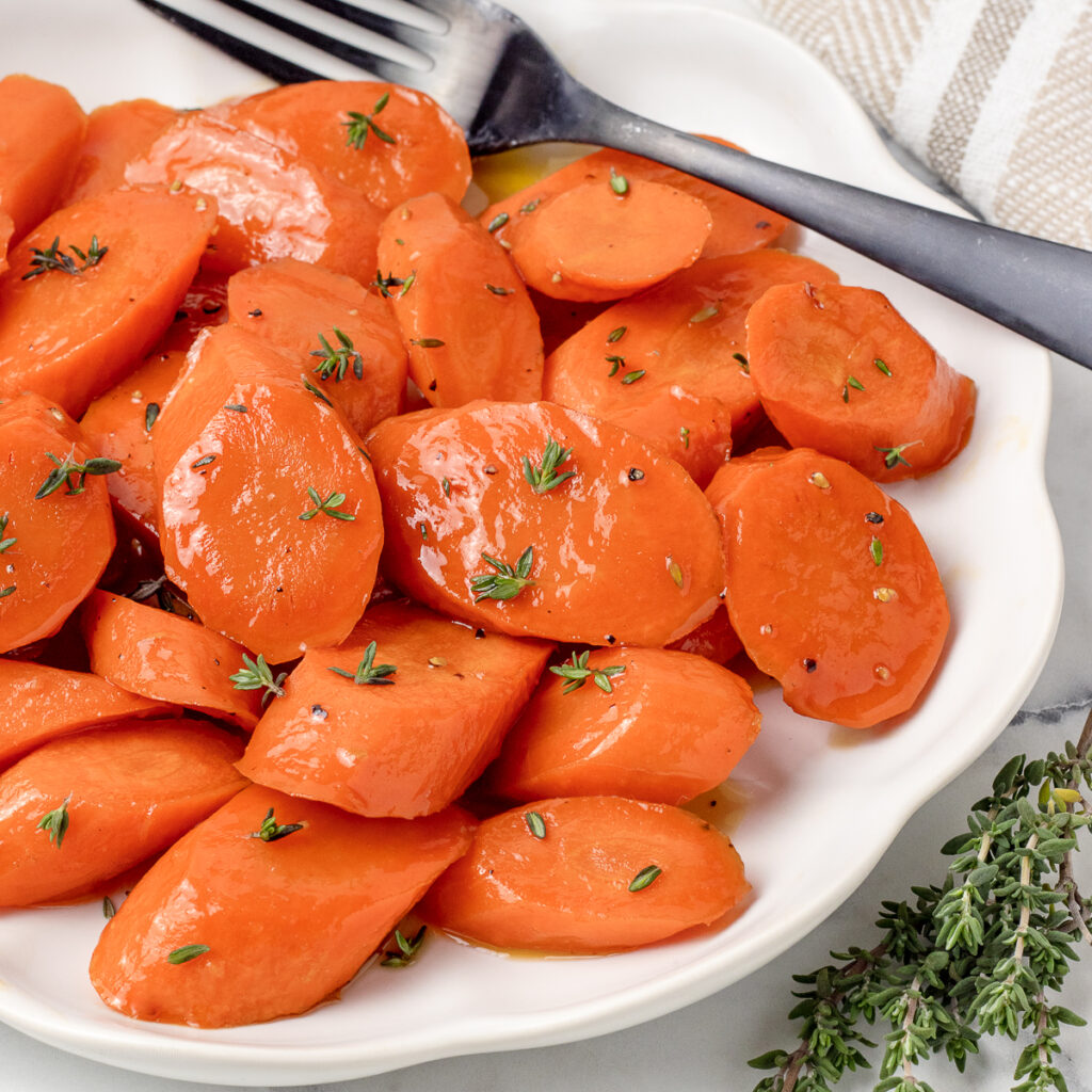 Honey Brown Sugar Roasted Carrots on a plate and garnished with thyme.