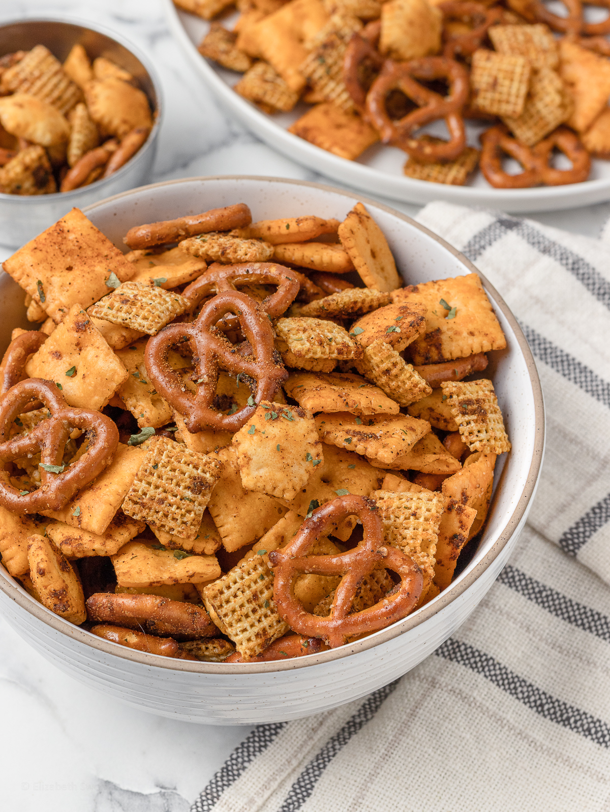 Bowl of Taco Snack Mix topped with dried parsley flakes.