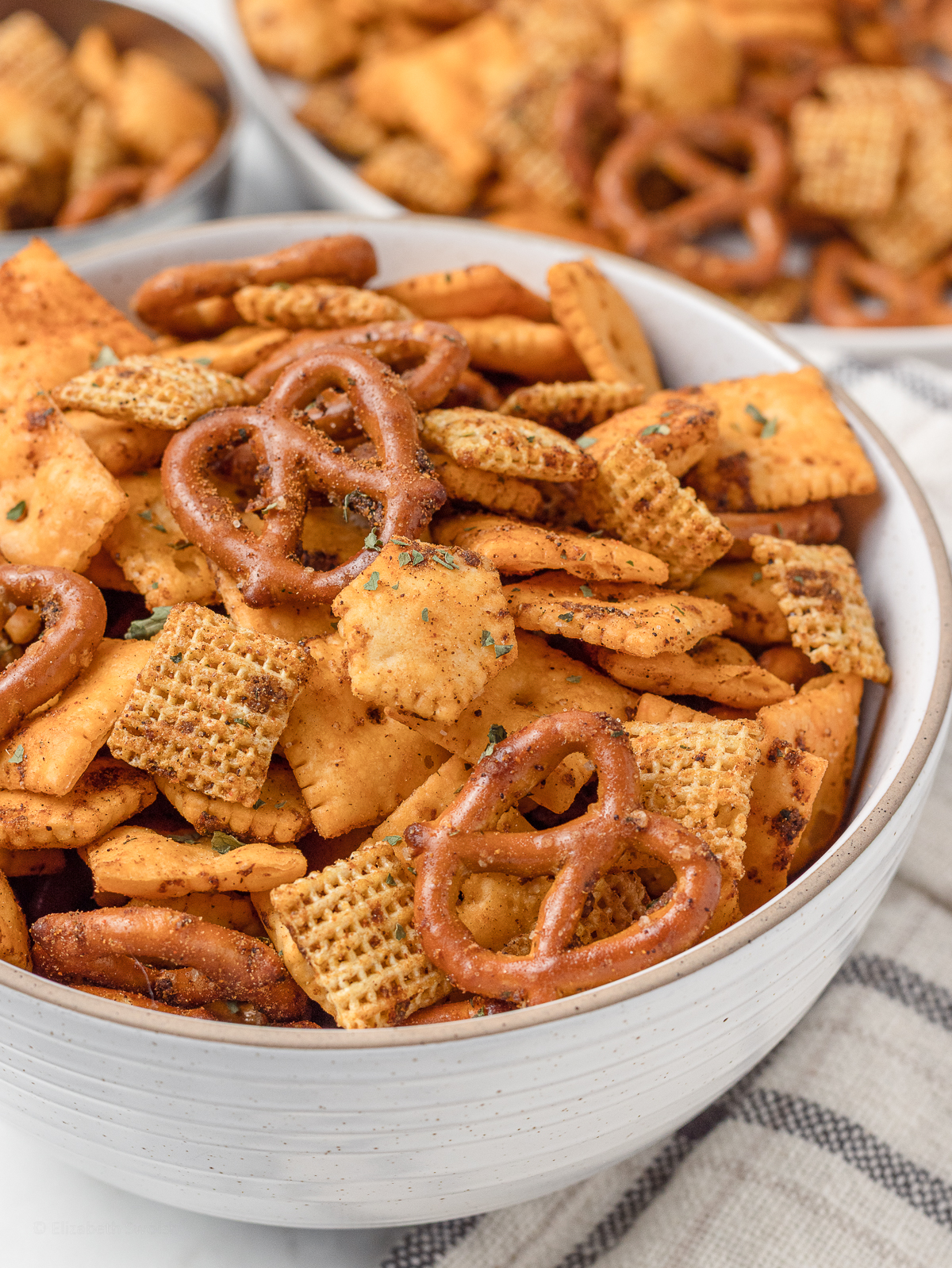Close up of Taco Snack Mix to see it coated with taco seasoning and dried parsley flakes.