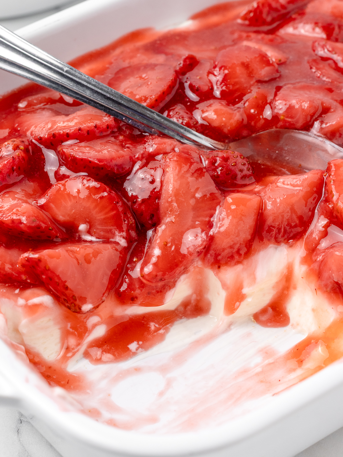 Strawberry Cheesecake Dip with some removed and the spoon in it for serving.