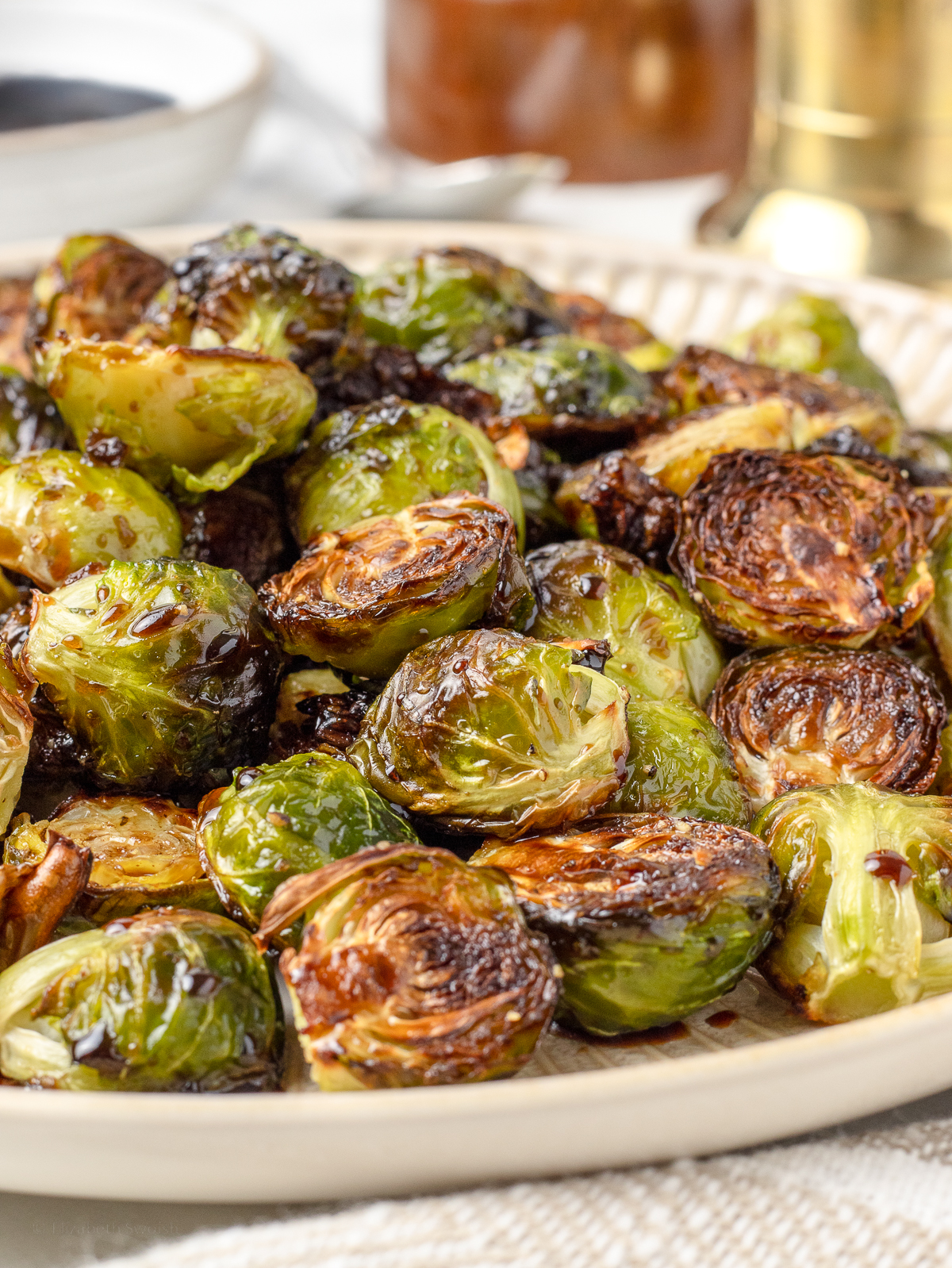 Close up of the brussels sprouts to see their crispy, caramelized edges, and the light coating of balsamic honey sauce.