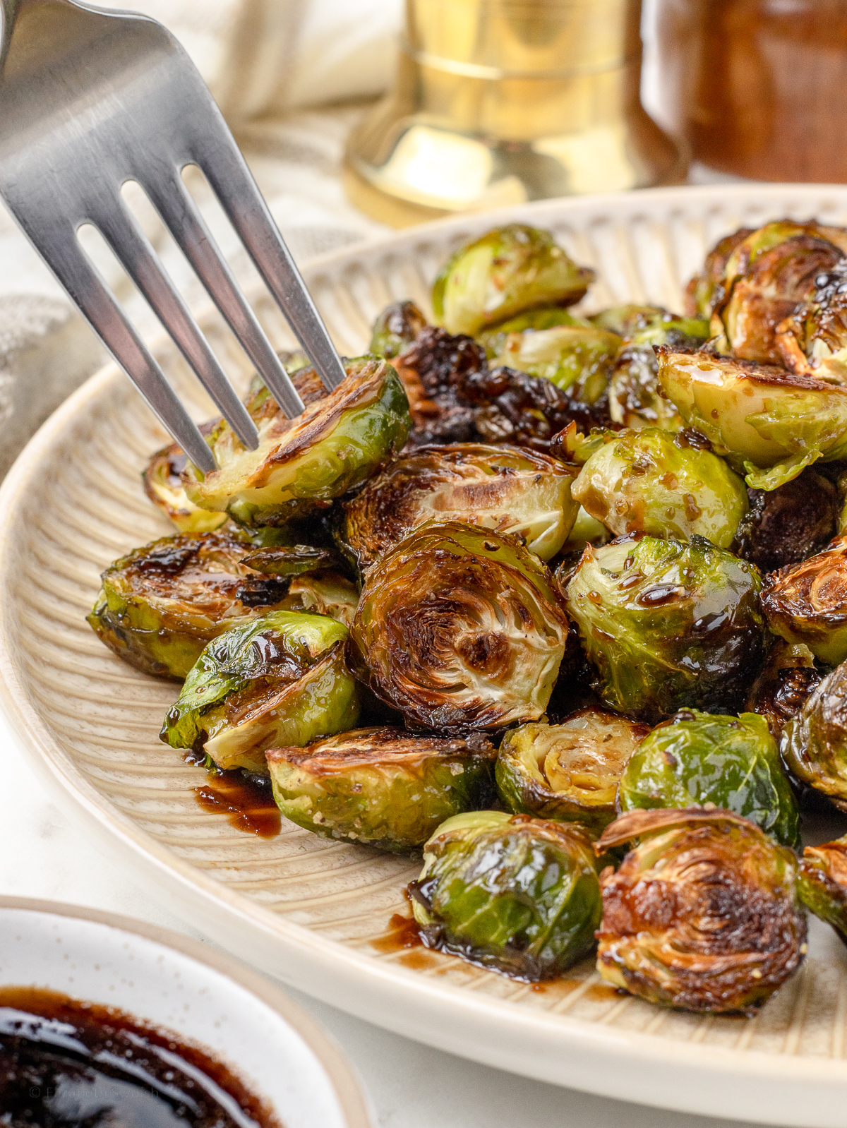 Fork grabbing a roasted brussels sprouts from the platter.