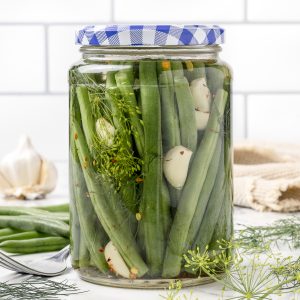 Jar of Quick Pickled Green Beans, also known as Dilly Beans. They're flavored with fresh garlic, fresh dill, and red pepper flakes.