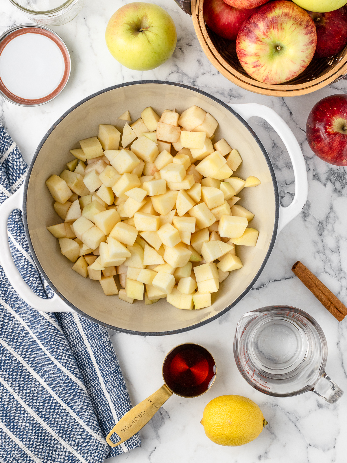 Ingredients, a variety of apples, maple syrup, lemon juice, water, and fresh cinnamon sticks.
