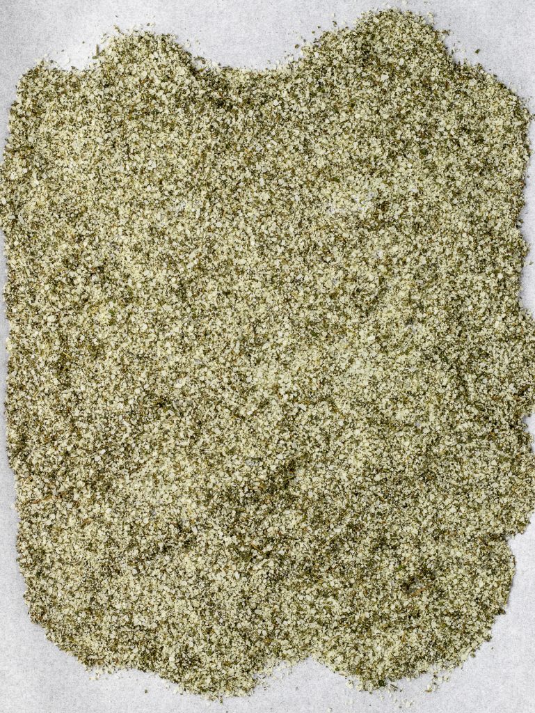 Baking sheet lined with parchment paper and topped with the herb and salt mixture. It's ready to dry down in the oven.