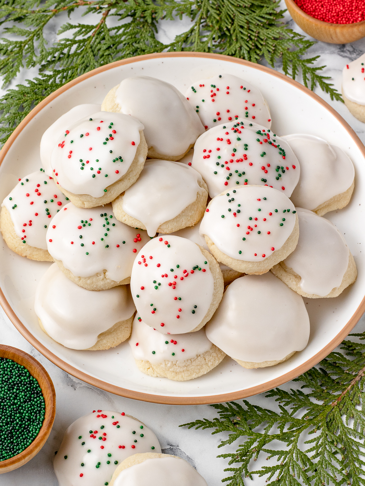 Plate of Meltaway Cookies with bowls of sprinkles on the side.