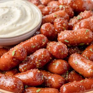 Honey Mustard Sausages dusted with parsley and a dijon mayo dipping sauce on the side.