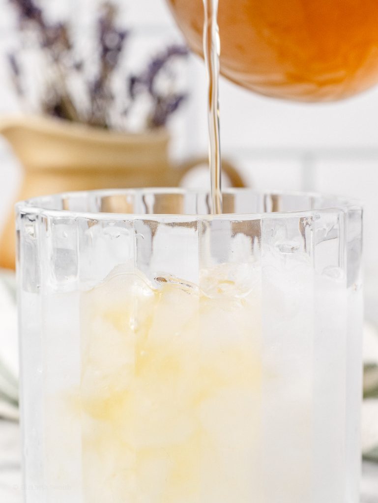Pouring the syrup into a glass of sparkling water to make a lavender spritzer.