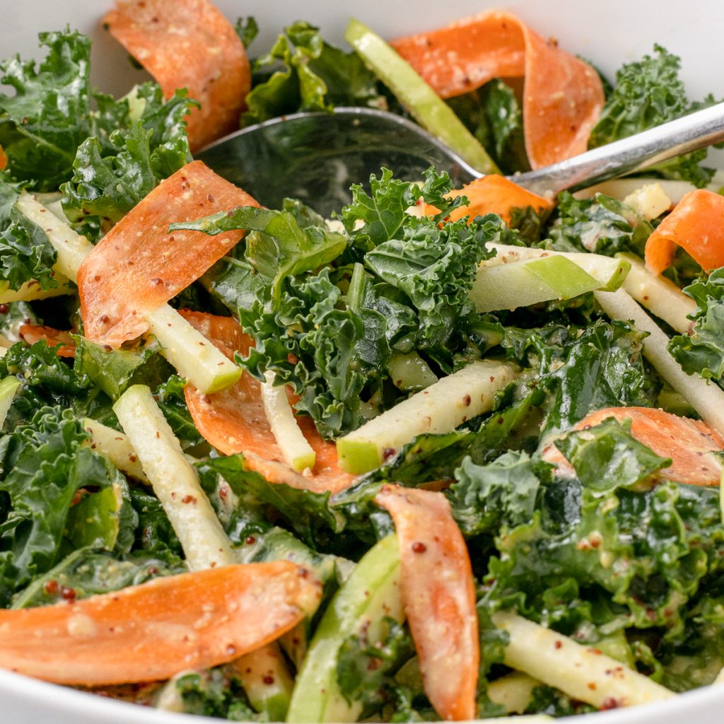 Apple Kale Slaw with ribbons of carrots and a honey mustard dressing.