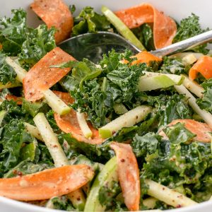 Apple Kale Slaw with ribbons of carrots and a honey mustard dressing.