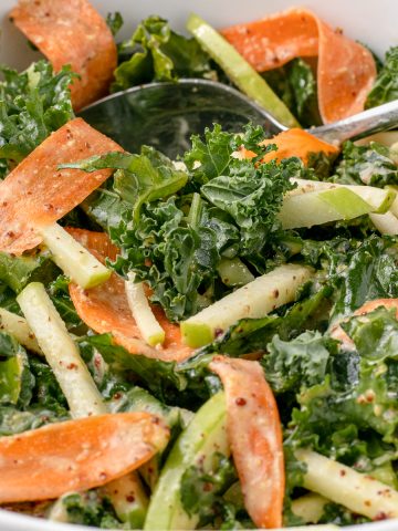 Apple Kale Slaw with ribbons of carrots and a honey mustard dressing.