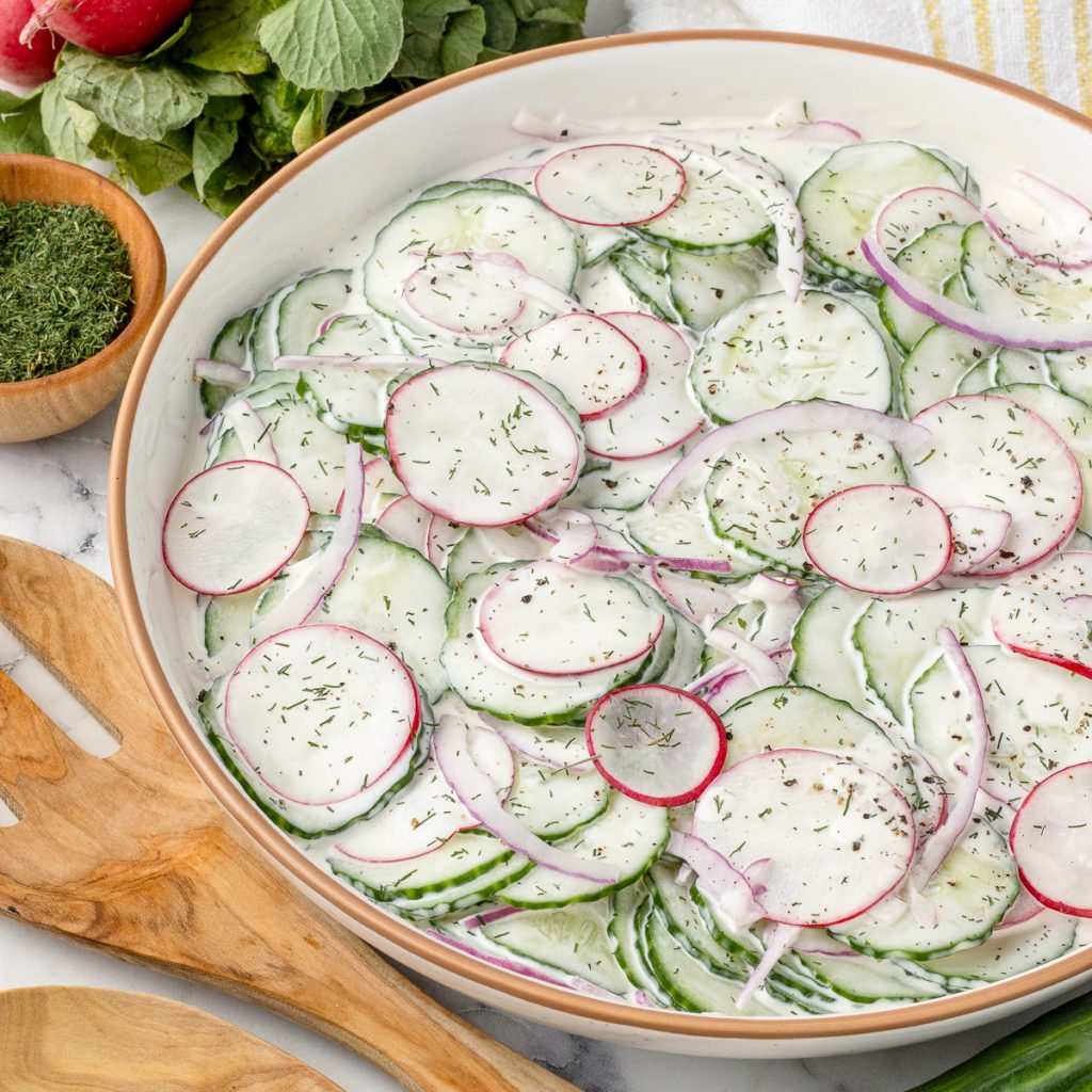 Cucumber Radish Salad tossed in a sweet and creamy dressing with red onion, dill, and black pepper.