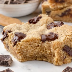 Bite taken out of a Peanut Butter Chocolate Chunk Bar. It's soft, chewy, and studded with chocolate chunks.