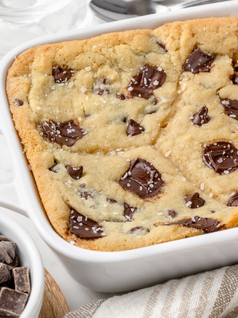 Baking dish of the golden brown Scoopable Cookies topped with flaky sea salt.