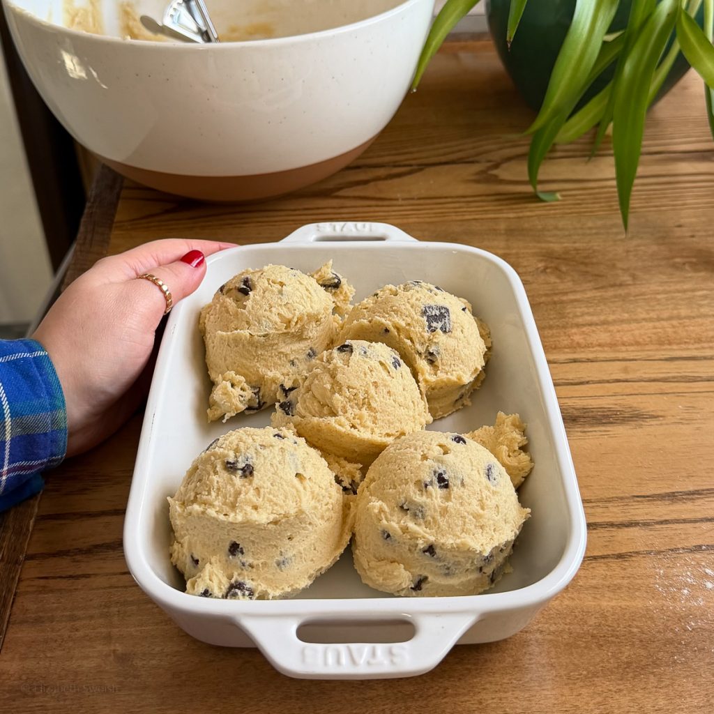 5 extra large portions of Chocolate Chip Cookie Dough placed in a lightly greased baking dish, ready to go in the oven.