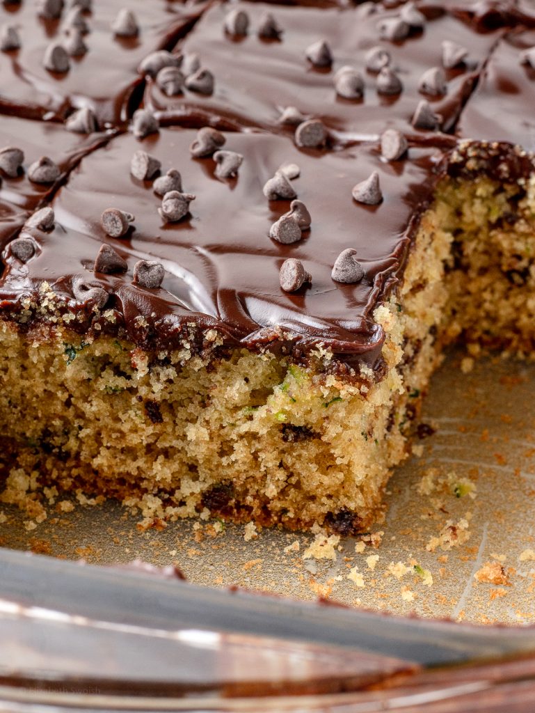 Close up of the cake to see it's soft, tender crumb and creamy frosting. There's flecks of zucchini and chocolate chips in the cake too.