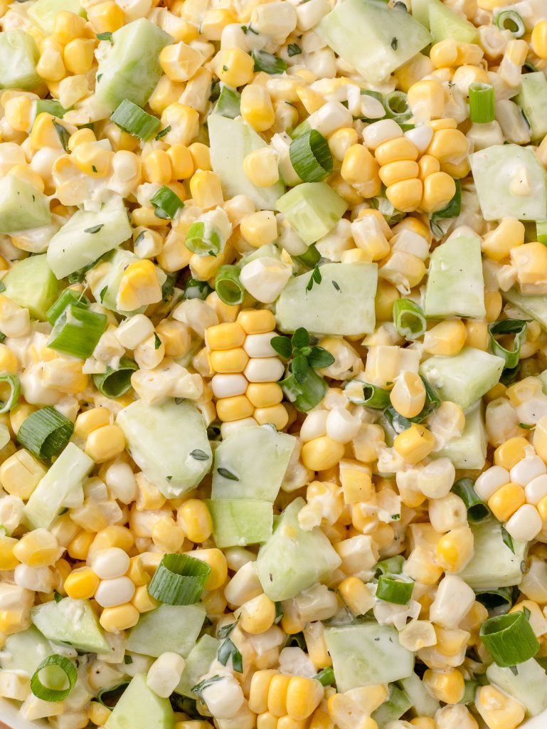 Close up to see the corn, cucumbers, and herbs coated in it's creamy dressing.
